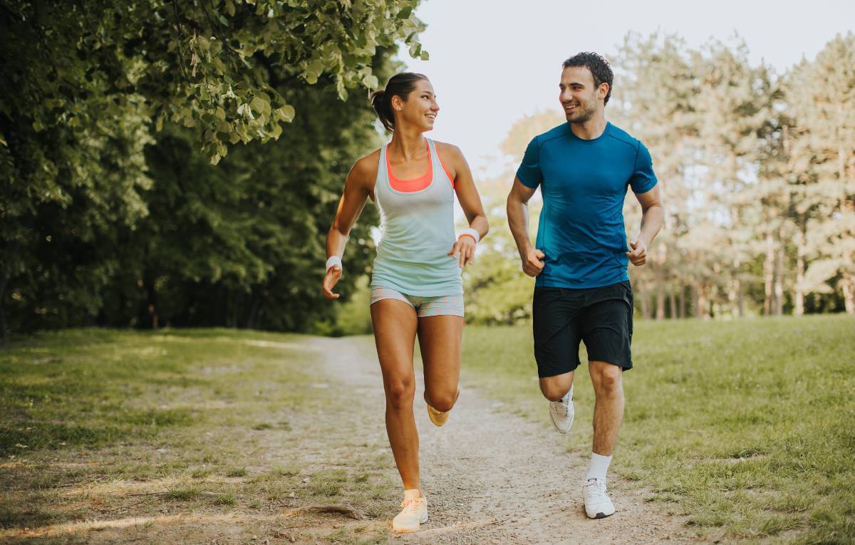 A man and woman running in a park