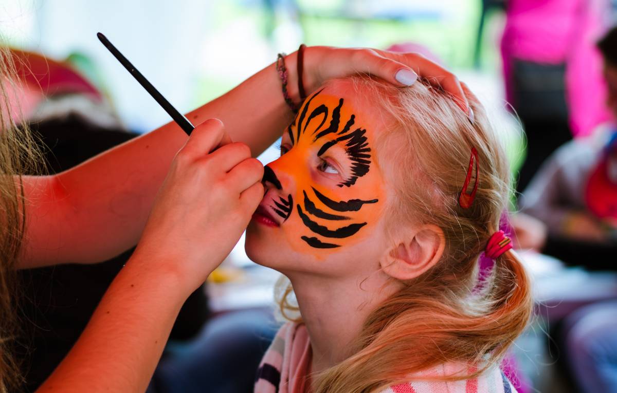 A child having a tiger painted on their face
